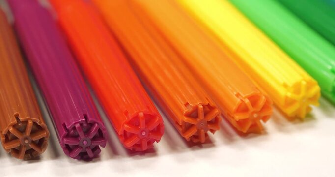 Many-coloured felt-tip pens lies on white table. Multicolored felt-tip pens for drawing. Colored plastic felt-tip pens of all rainbow colors
