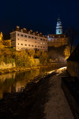 Fototapeta premium Cesky Krumlov Castle tower illuminating Vltava River at night