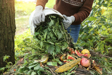 Compost heap pile with bio waste. Farmer with food waste, scrap of vegetables and fruits with...