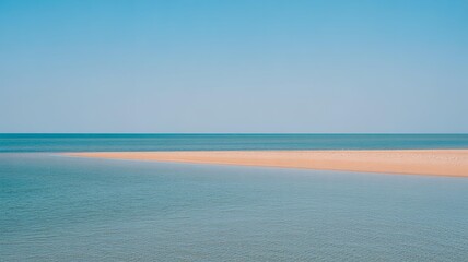Obraz premium Serene beach scene with calm ocean waves and clear blue sky at sunset reflecting on wet sand