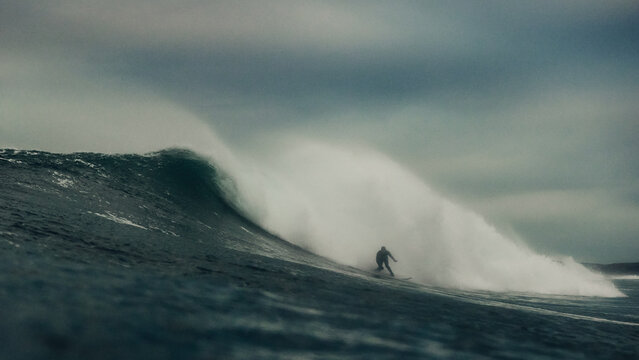 surfer on a big wave in dark stormy conditions