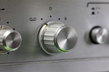 The detail depicts an old audio system device, specifically a signal source knob
