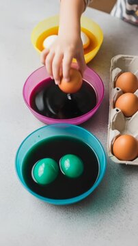 Child dipping eggs in vibrant dye for holiday celebration crafting