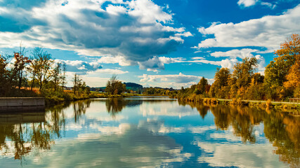 Fototapeta premium Autumn or indian summer view with reflections in a lake at Unteriglbach reservoir, Ortenburg, Passau, Bavaria, Germany