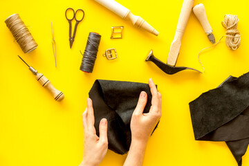 Leather craftsman or shoemaker on workplace with tools, top view