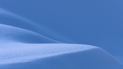 Soft blue snowdrift layers forming smooth abstract curves. Minimal winter background with gentle gradients, clean texture and calm cold atmosphere, perfect copy space for design.