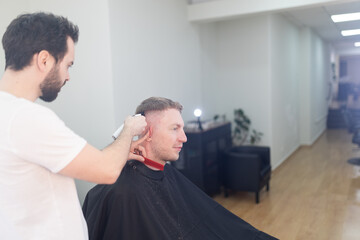 Obraz premium Professional barber giving male client a fresh haircut