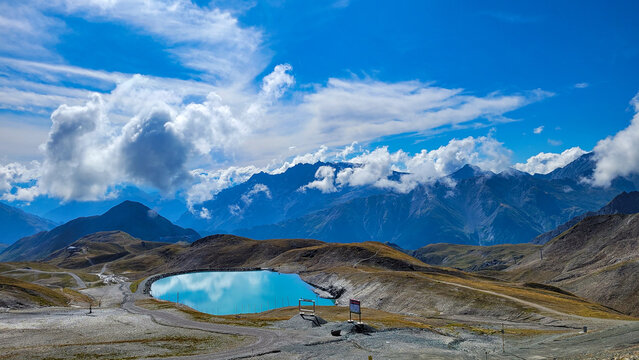 The picturesque emerald lake in the Austrian Alps against the background of blue sky with white clouds. Austrian und Swiss mountain landscapes.