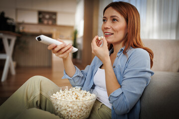 Enjoying popcorn while watching TV at home