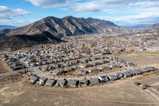 Aerial view of New Castle, Colorado residential area under sunny late autumn cloudscape.