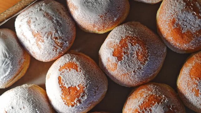 Powdered sugar donuts in bakery box, close up food background