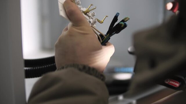 Electrician preparing wall outlet wires for installation
