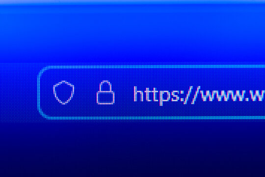 Close up of a web browser search bar on a blue pixelated screen showing a secure https prefix with a flashing cursor, representing web navigation, internet connectivity, and cyber security.