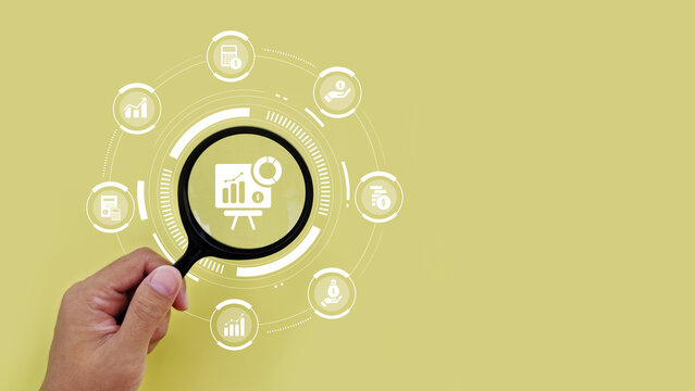 Magnifying glass highlighting business chart and analytics icons, representing data analysis, performance tracking, growth strategy and reporting.