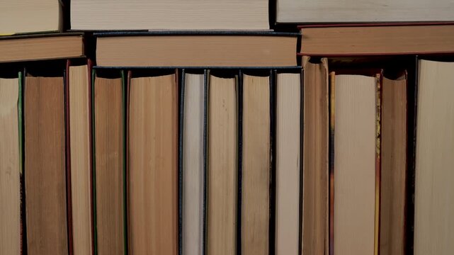 Books spines background texture for library and education concept, Row of hardcover books standing close together symbolizing knowledge and learning