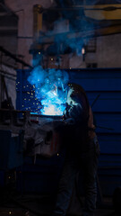 Fototapeta premium engineer welds metal on a freight car. sparks and smoke. welding. train and freight car manufacturing plant. metallurgical production, metal processing, heavy industry manufacturing process, factory