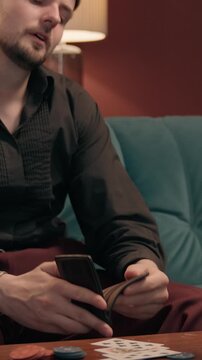 Frustrated Caucasian male gambler looking empty wallet losing money casino poker disappointed broke man guy player cash bankruptcy betting loss gambling addiction game playing failure at home indoors