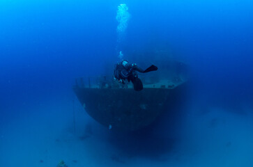 Scuba diver next to stern of Um El Faroud shipwreck, Wied iż-Żurrieq, Malta, Mediterranean Sea