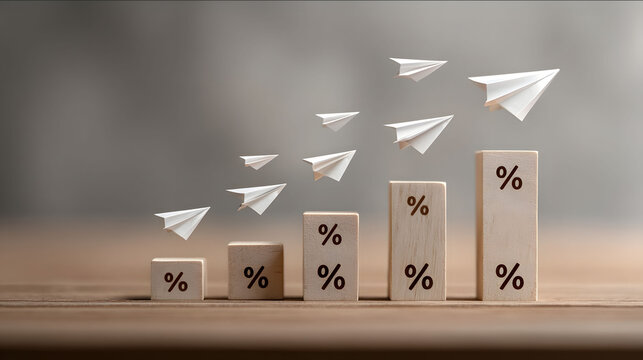 Business concept image showing wooden blocks stacked like a bar graph each block marked with a percentage symbol Five small white paper airplanes flying upwards in
