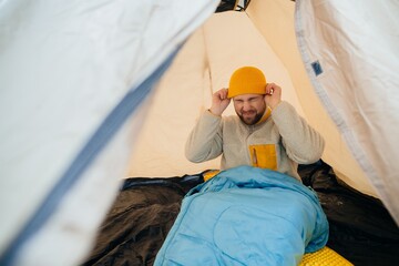 Man struggling with discomfort during winter camping © dsheremeta