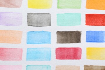 Fototapeta premium Painted watercolor strokes on white sheet of paper, top view