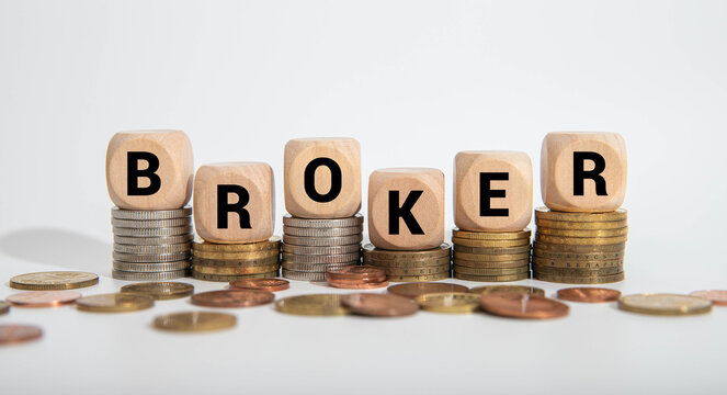 Hand turns wooden cube and changes the word broker to broke. Symbol for a wrong financial decision