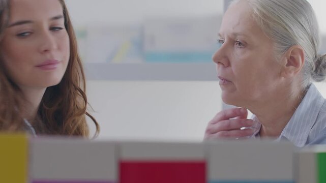 Female Pharmacist Recommending Throat Lozenges to Senior Woman