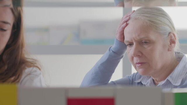 Smiling Pharmacist Advising Senior Woman on Headache Relief Pills in Modern Pharmacy
