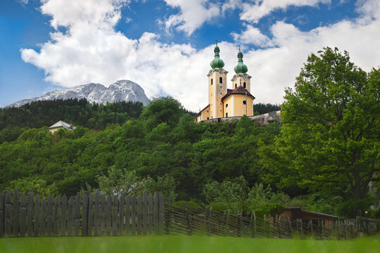 Scenic view of the yellow pilgrimage church of St. Anthony of Padua in Radmer an der Stube with the rocky Lugauer mountain peak in the background.