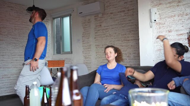 Family and friends on the edge of their seats watching a soccer football match, anticipating a goal attempt, then reacting with disappointment after the missed shot. Sports tension, game night emotion