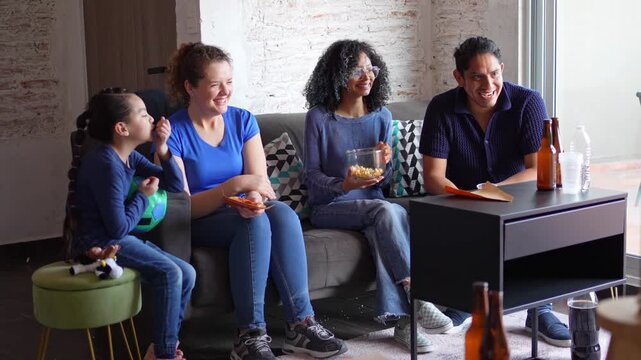 Friends eating pizza while watching football soccer on TV, the screen is not visible. Sports snacks, casual gathering, friendship, shared enjoyment, home viewing