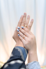 Woman's hands with stylish blue glitter nails and gold rings