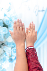 Couple showing wedding rings together with beautiful manicure and elegant red sleeve