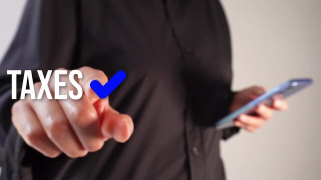 A businesswoman holding a smartphone while pointing forward at an animated version of the word "Taxes" with a blue check mark. Taxes paid.