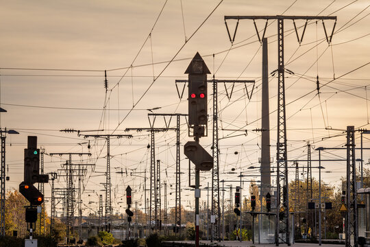 Recently reconstructed railway tracks and modernized platforms at a suburban station in Germany, with new structures, overhead wires and multiple signal lights forming an infrastructure grid at sunset