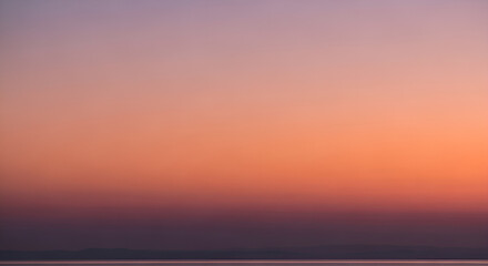 Fototapeta premium Sunset over serene landscape with vibrant sky and silhouette of hills