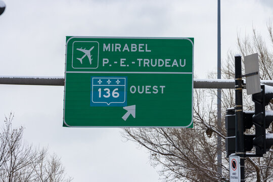 Canada, Montreal, 25 December 2025 : Green highway sign directing to airports westbound in wintertime.