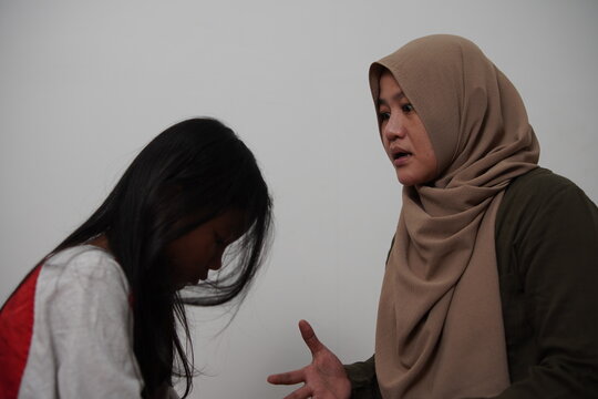 Angry Asian Muslim mother scolding her daughter