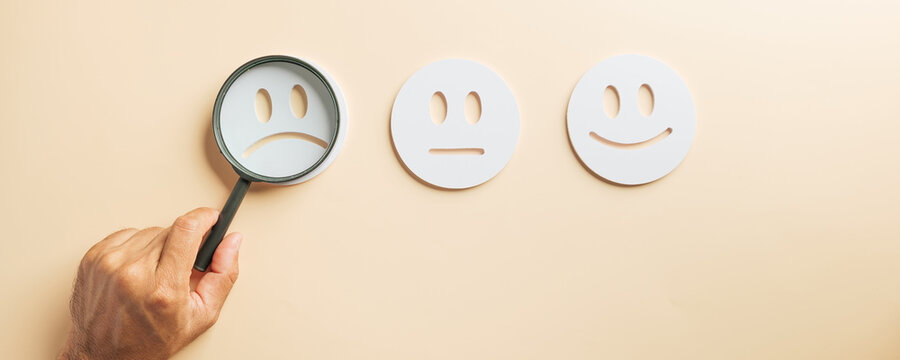 Customer satisfaction magnifying glass concept highlights service quality, showing happy face, neutral face, sad face for business improvement and valuable feedback insights