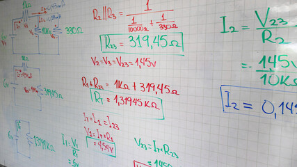 Hand-written circuit diagrams and mathematical formulas on a whiteboard. Concepts of resistance, voltage, and current for physics education and engineering studies. © HumbertoJose92