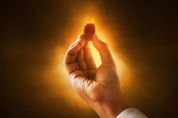 Hand of young muslim man holding dates fruit on dark background, eid adha mubarak concept
