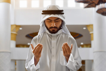 Portrait of young asian muslim man with beard praying in the mosque, eid adha mubarak concept