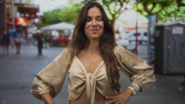 Woman pointing thumb to the side with midriff visible and smiling on a busy city street; confidence exploration.