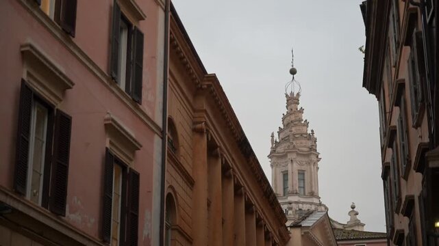 A low-angle view of the unique corkscrew spiral lantern and concave facade of Sant Ivo alla Sapienza, designed by Francesco Borromini, within the courtyard of the old University of Rome