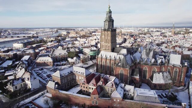 Medieval Hanseatic Dutch tower town Zutphen in the Netherlands covered in snow with historic heritage buildings and river IJssel passing by in the background behind