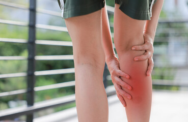 Close up of woman standing and massaging her painful calf with red highlight. Leg cramp, muscle strain, deep vein thrombosis and sport injury concept for health care and physical therapy. © TripleP Studio