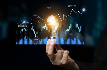 A hand holds a glowing light bulb against a backdrop of financial graphs and data, symbolizing innovation and analytical thinking in business and investment strategies. Scalp