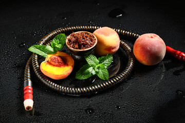 Parts of hookah with tobacco, peaches and mint leaves on black background © Pixel-Shot