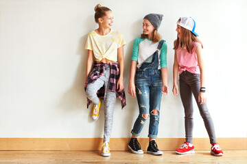 Fashion, talking and group of teenagers by wall for bonding, friendship or laughing together....