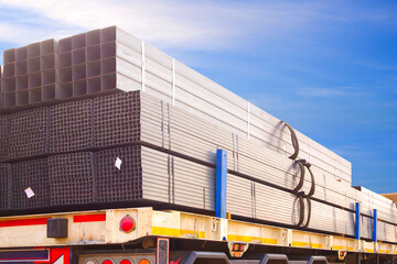Bundles of square steel tubes loaded on transport truck trailer for industrial construction...